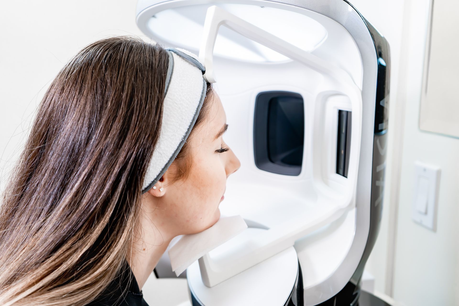 Woman using a facial scanning device in a clinic or spa