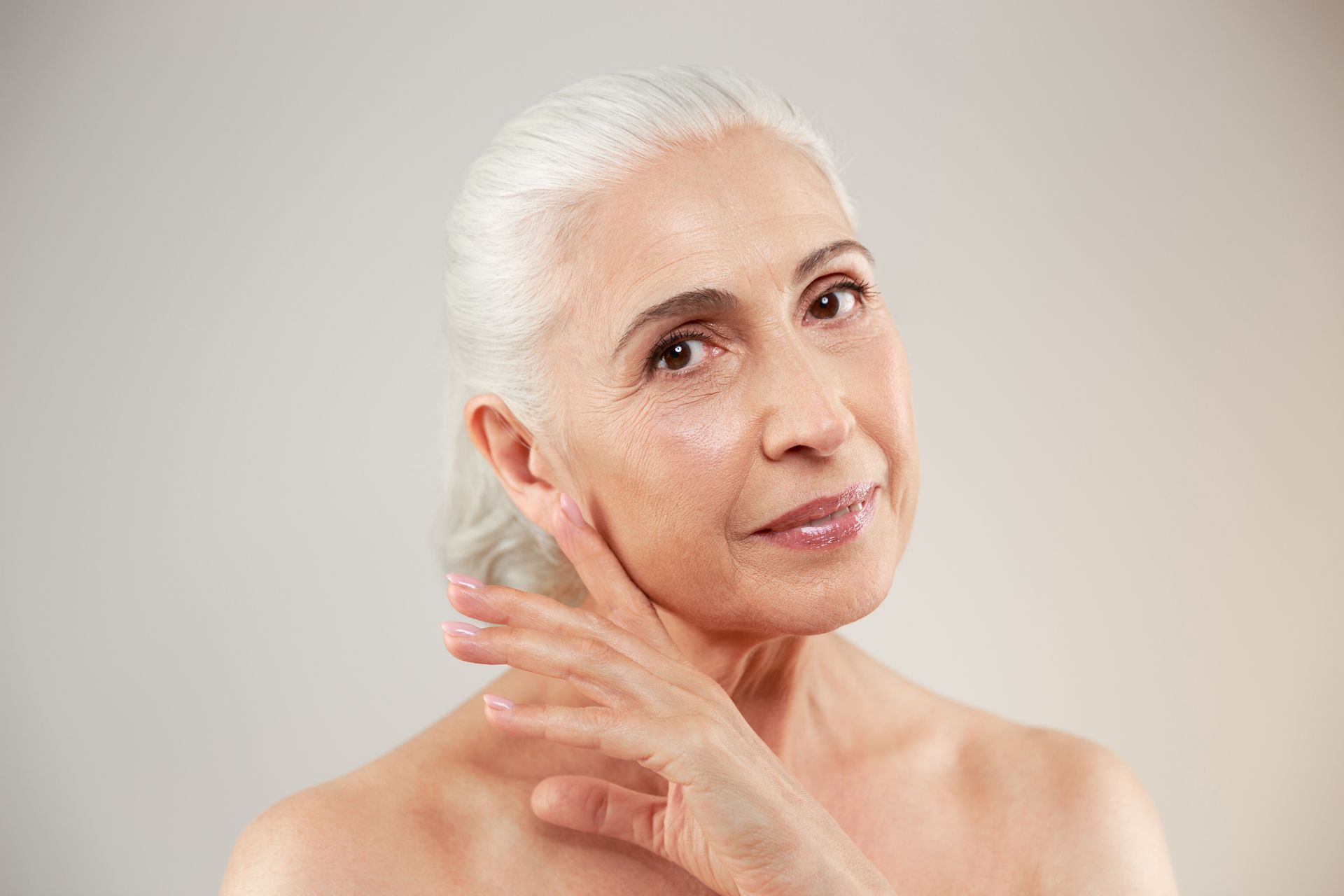 An elderly woman showing her face after Stylage Dermal Fillers treatment.