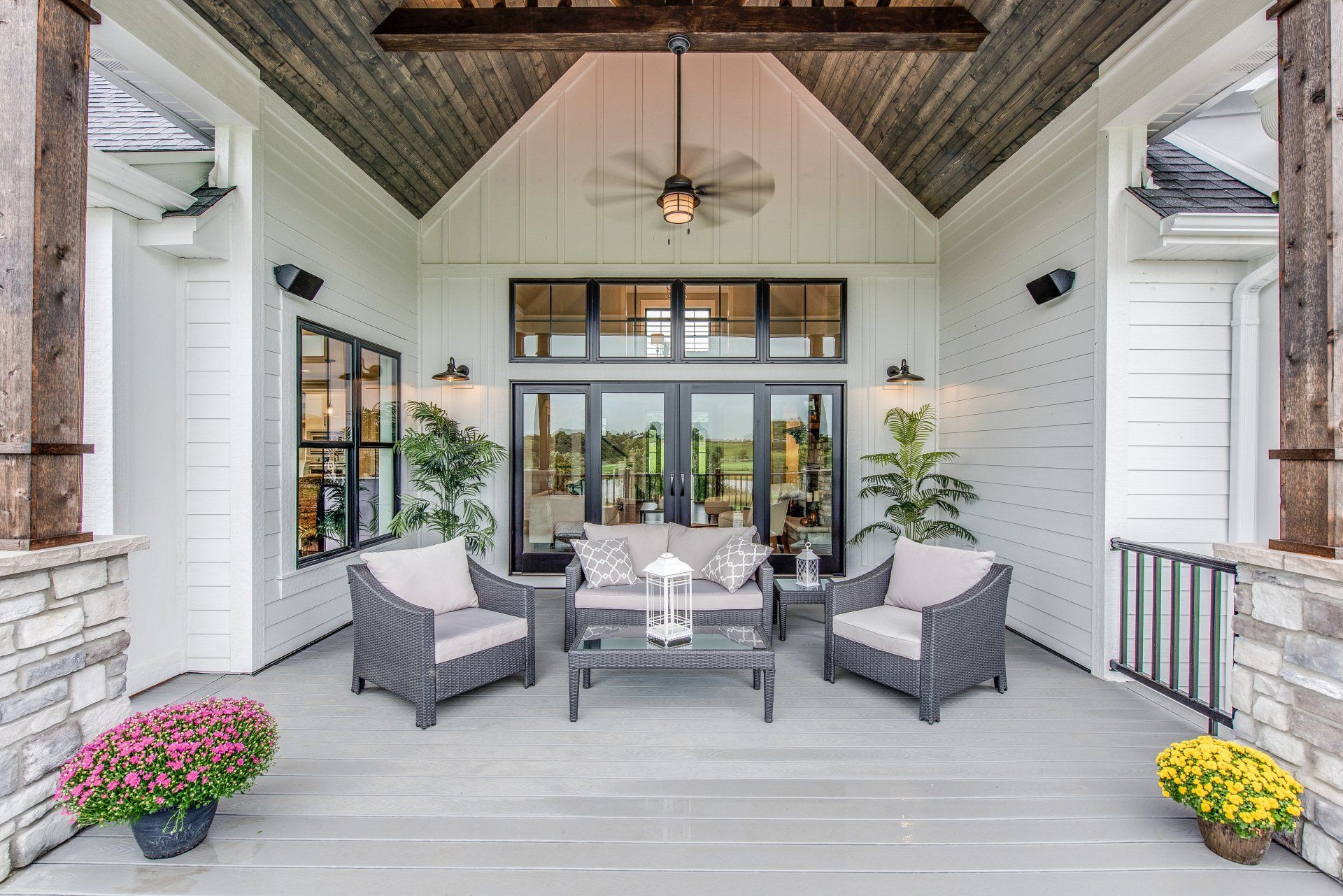 A large covered patio with furniture and a ceiling fan.