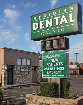 A green sign for meridian dental clinic welcomes new patients