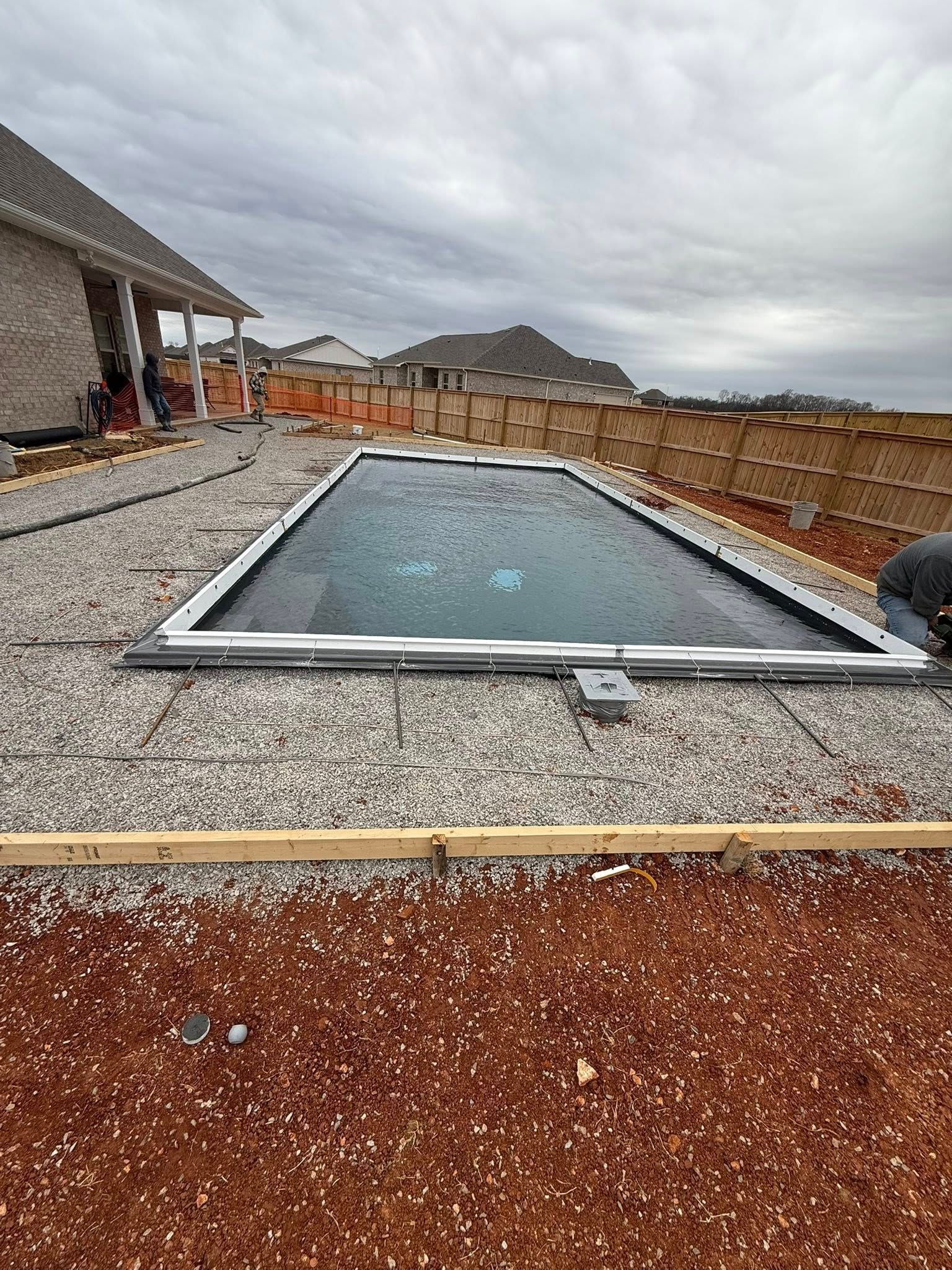 Flat rooftop with a rectangular skylight under a cloudy sky, gravel surface and distant mountains.