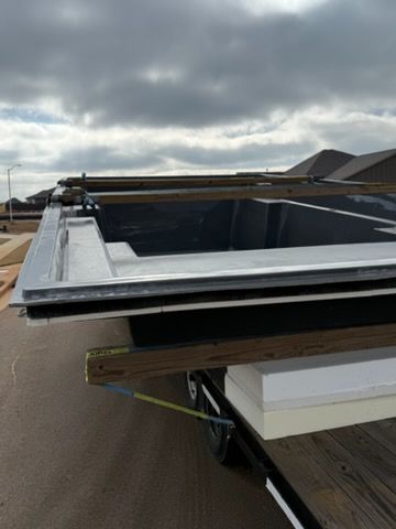 Rooftop opening with metal frame and dark interior under a cloudy sky