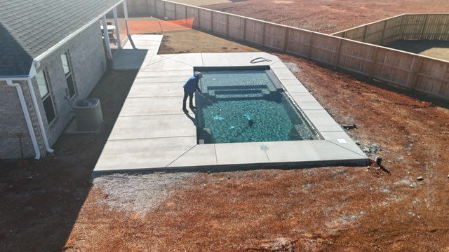 Backyard with a small rectangular in-ground pool beside a house and fenced yard