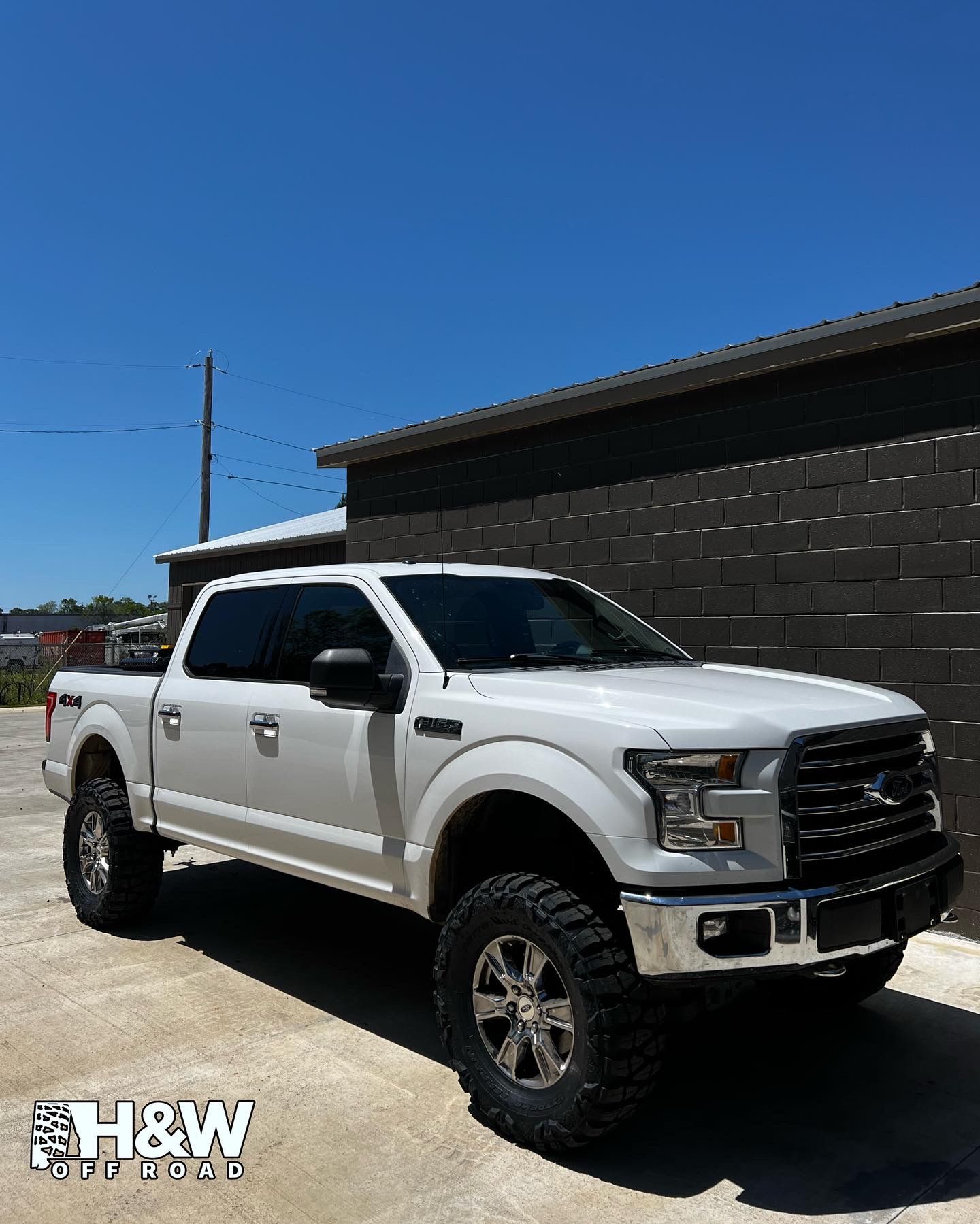 White Ford F-150 Truck Parked Outside Shop Under Blue Sky | Davis Tire Group