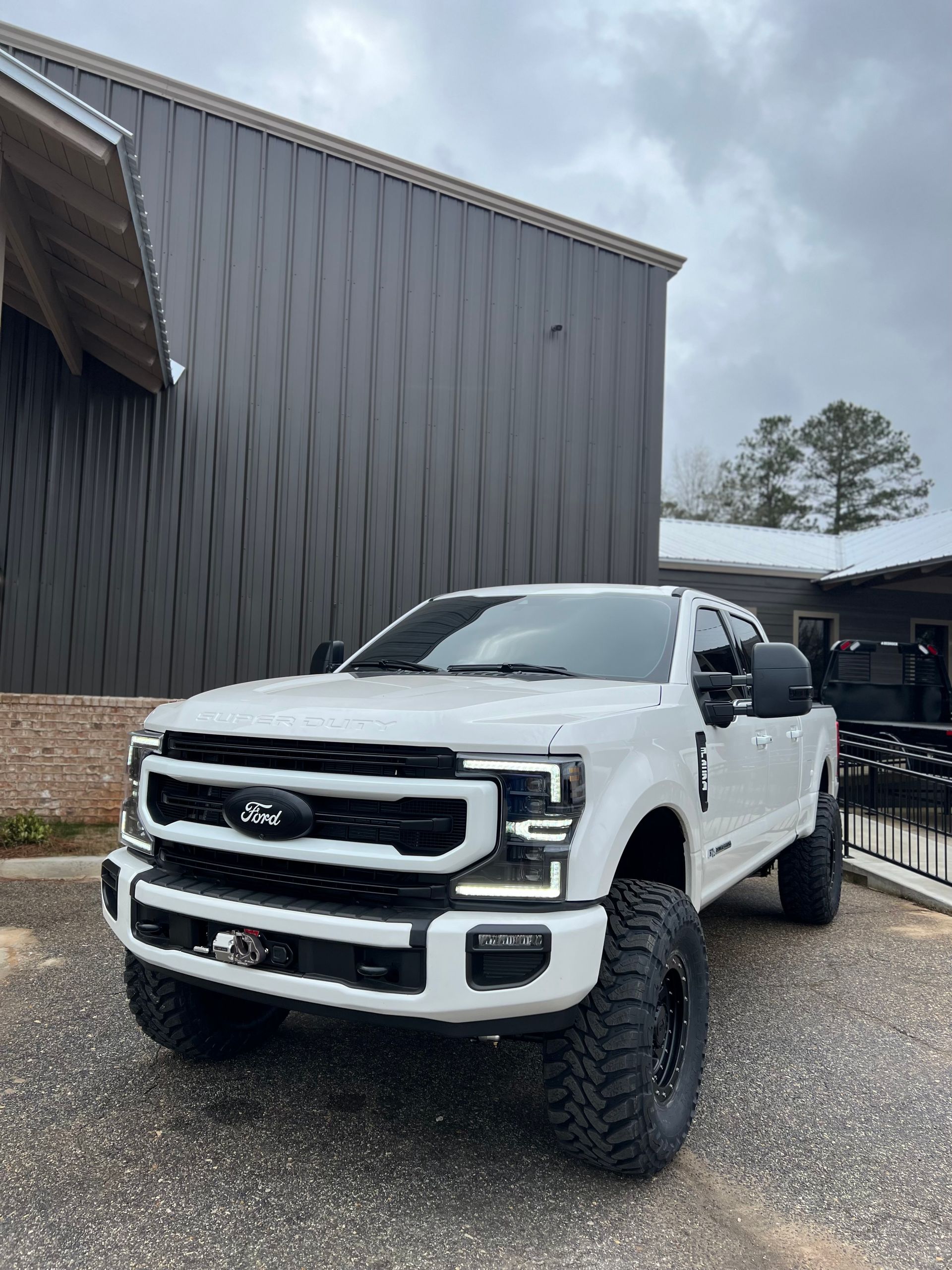 White Ford Super Duty Truck Parked Beside Metal Garage Building | Davis Tire Group