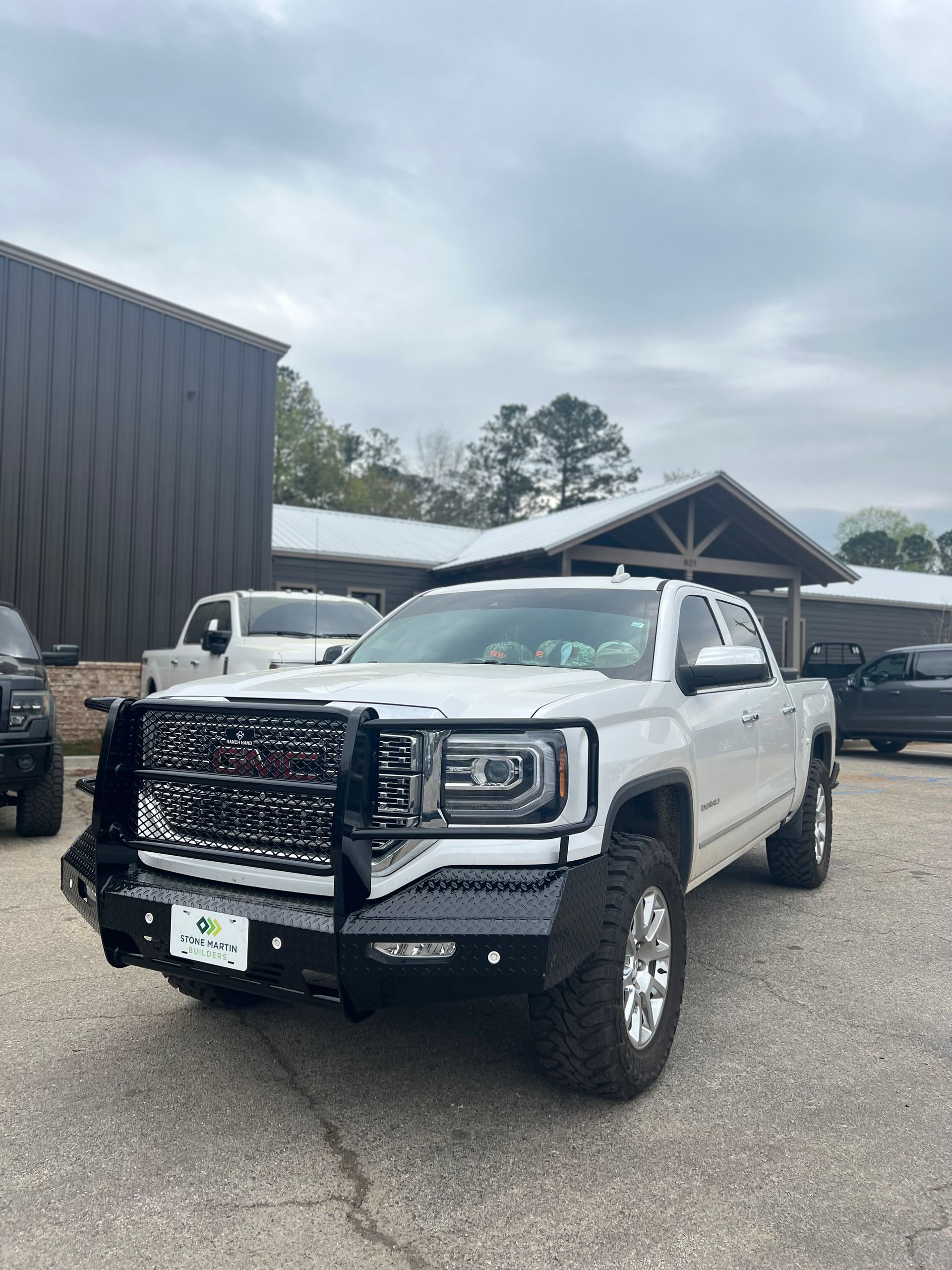 White Lifted GMC Truck Parked In Front Of Auto Shop Entrance | Davis Tire Group