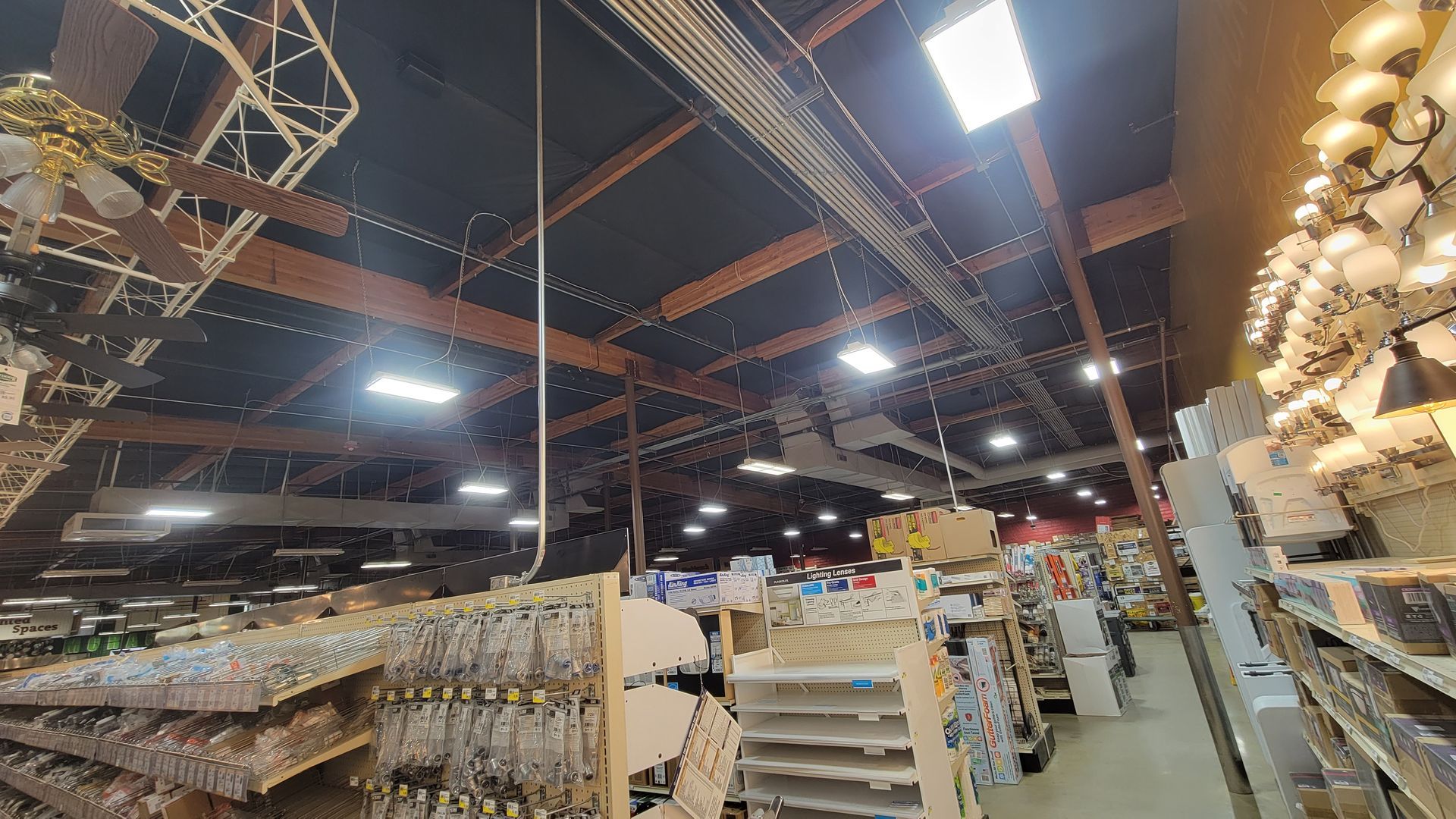 Indoor warehouse with shelves, pallets, and bright overhead lights in a large industrial space
