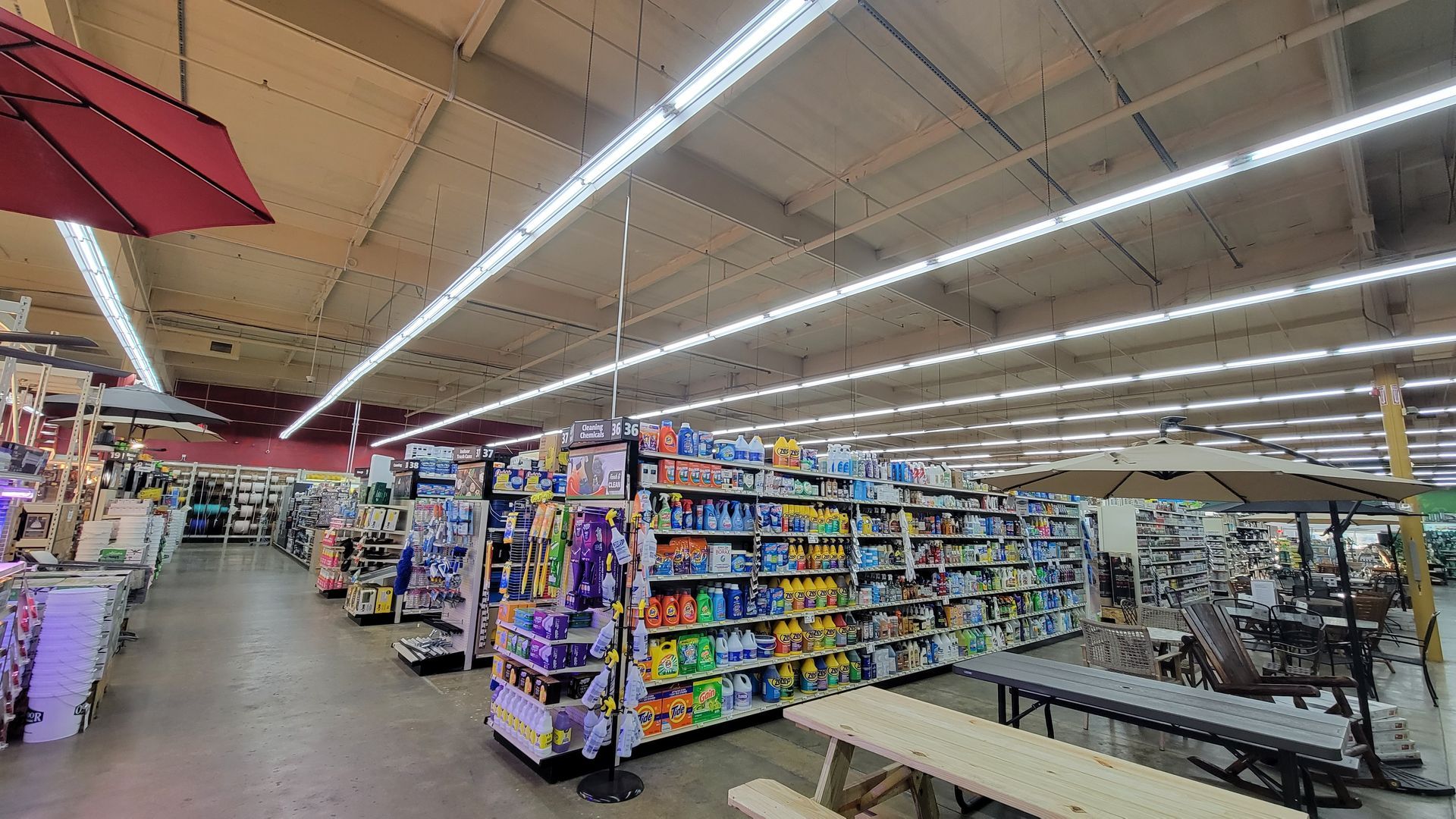 A bright convenience store aisle with shelves of snacks and drinks under long fluorescent lights.