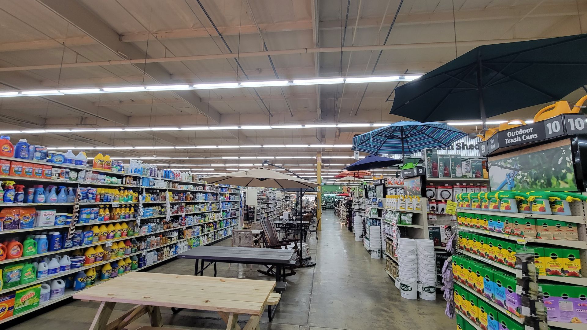 Grocery store aisle with shelves of colorful products and a few shoppers in the distance