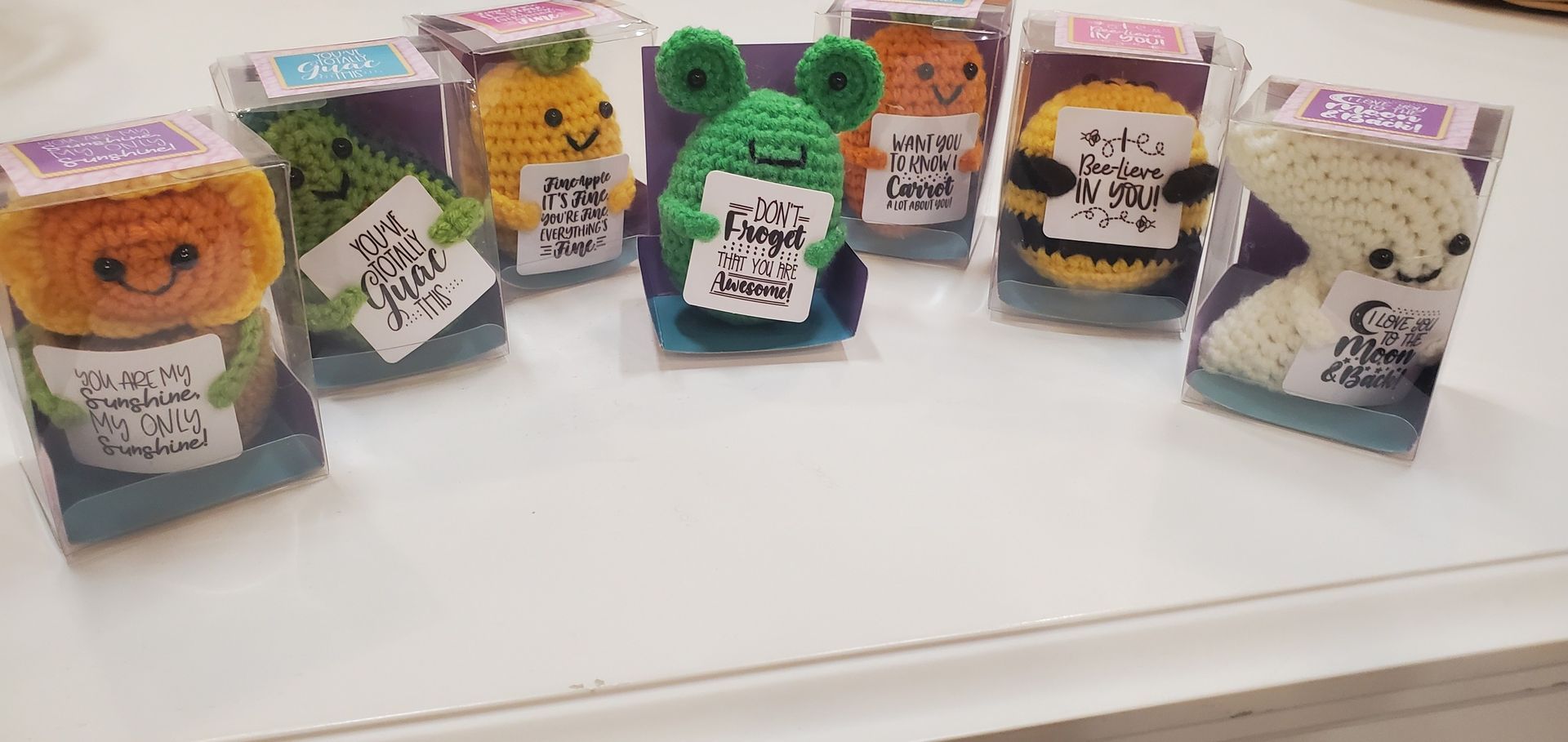 A bunch of crocheted animals are sitting on a table.