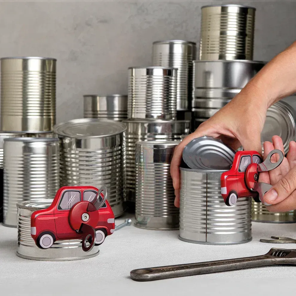 A person is opening a can with a toy car in it