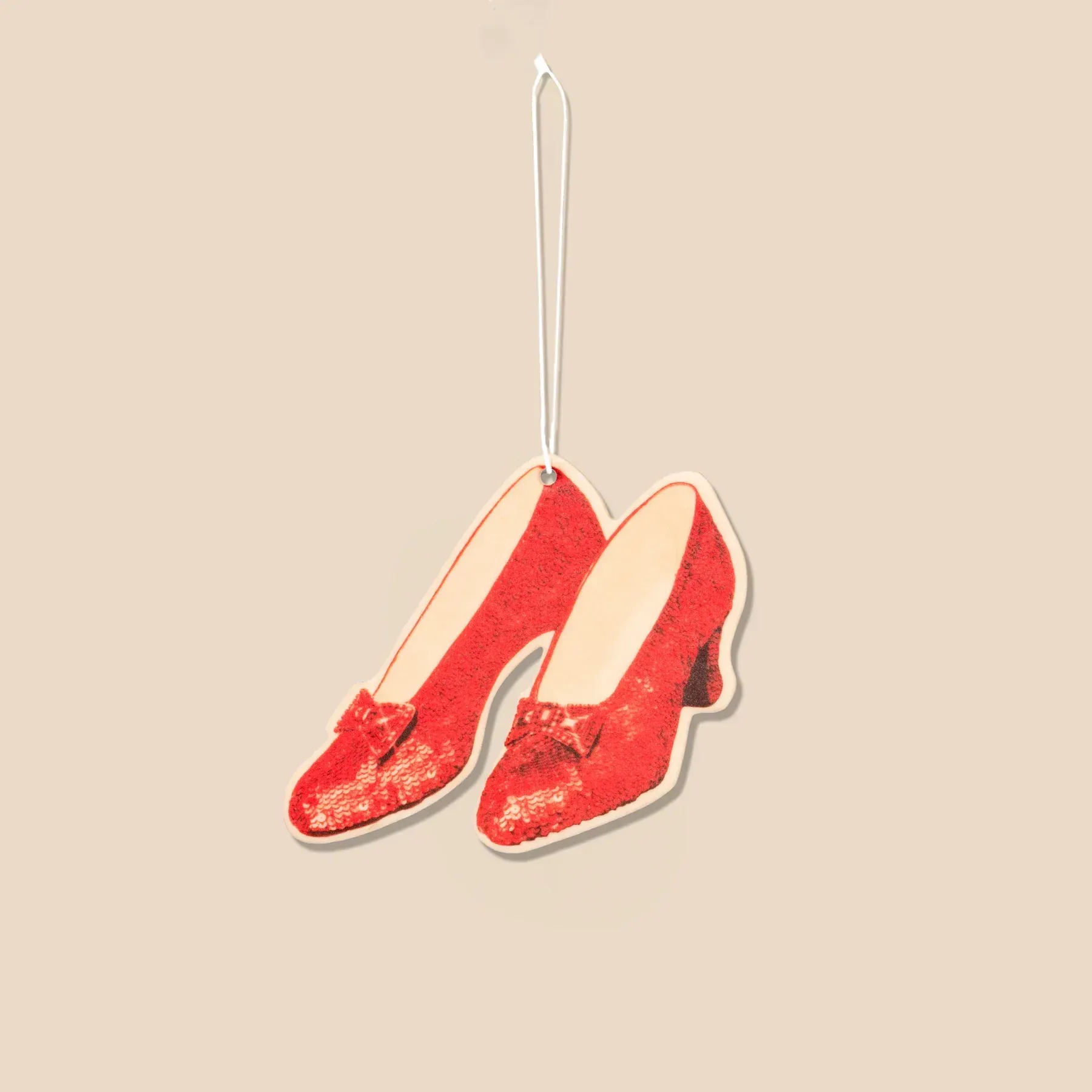 A pair of red shoes hanging from a string