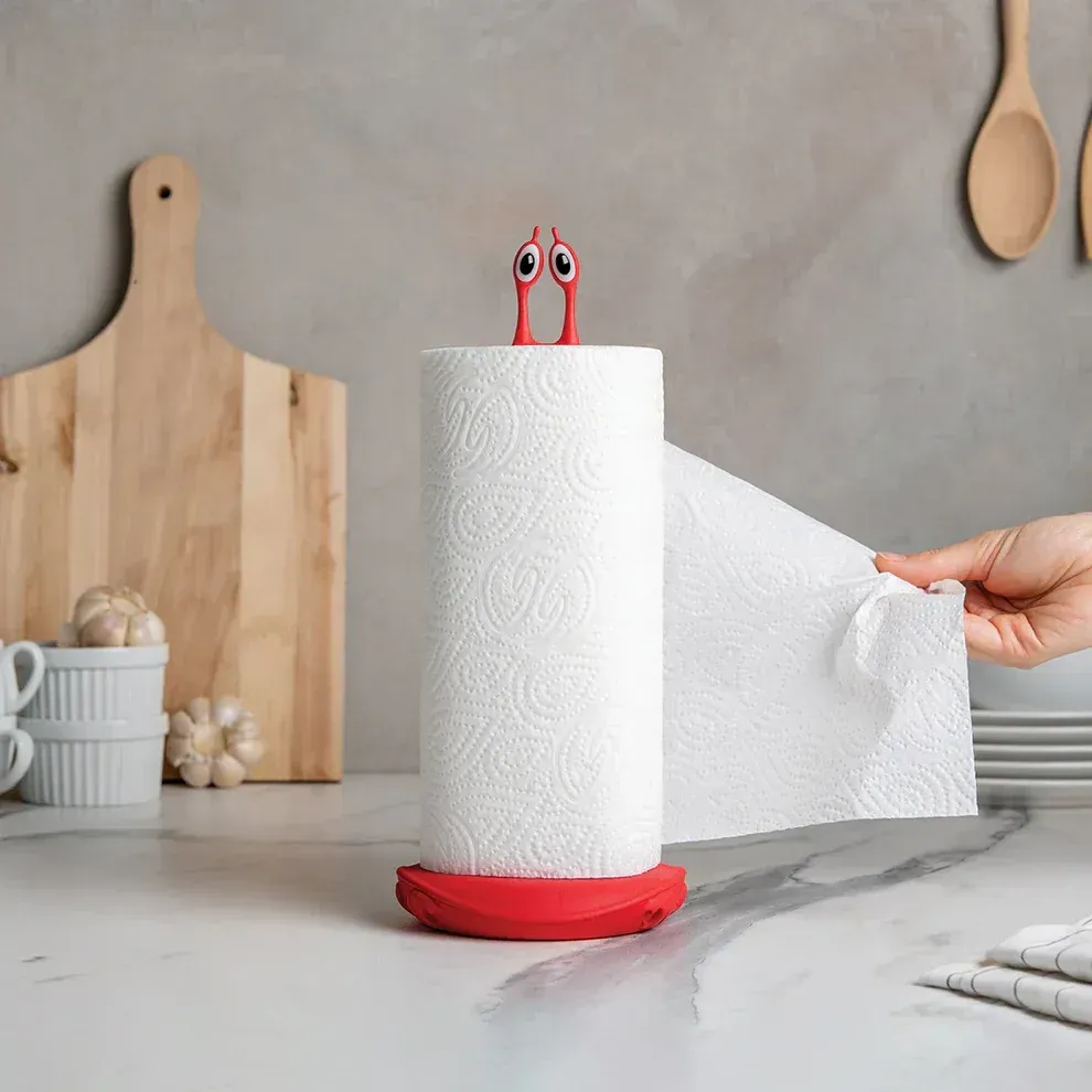 A person is holding a roll of paper towels on top of a paper towel holder.