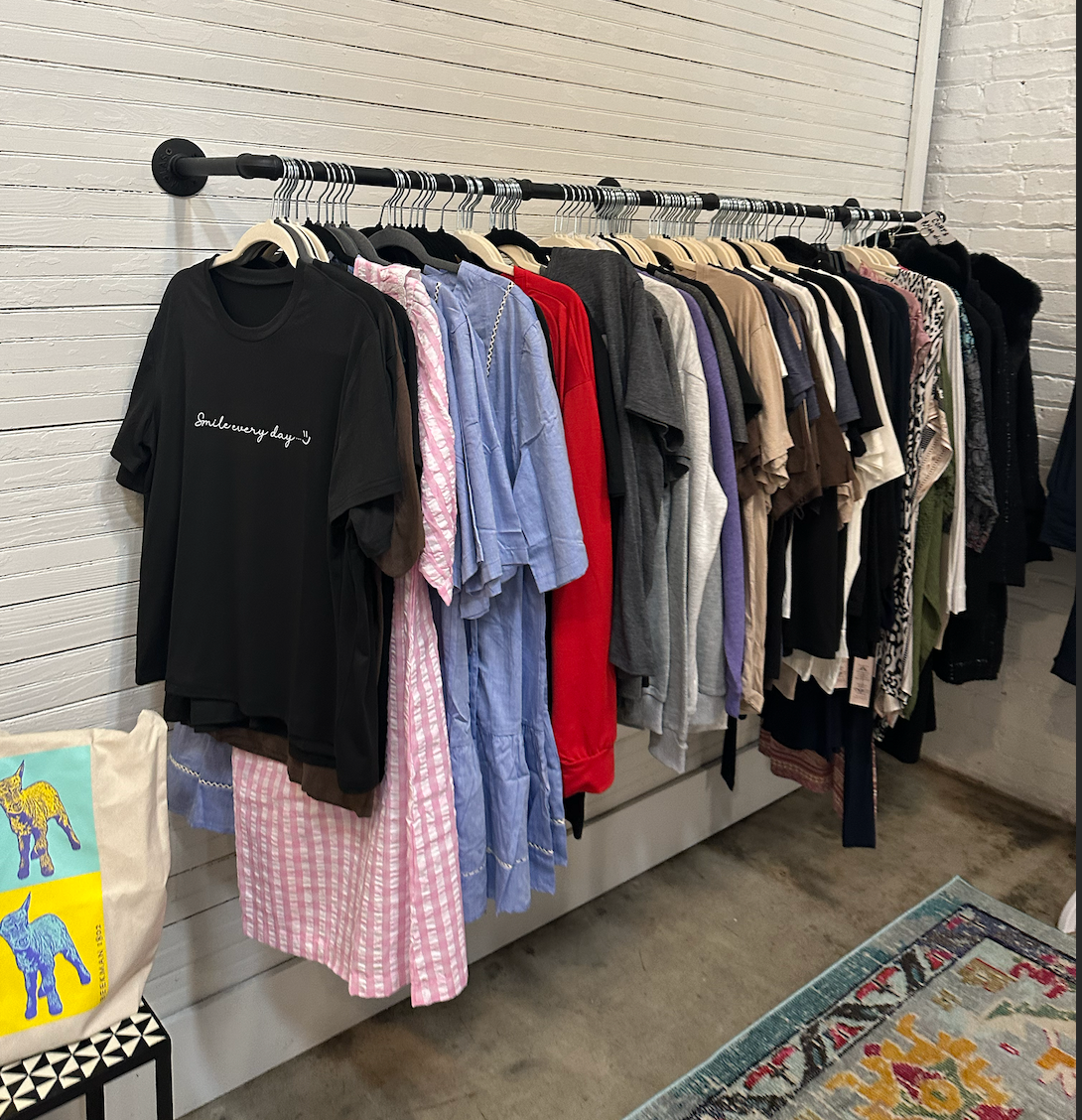 A bunch of clothes are hanging on a rack in a store