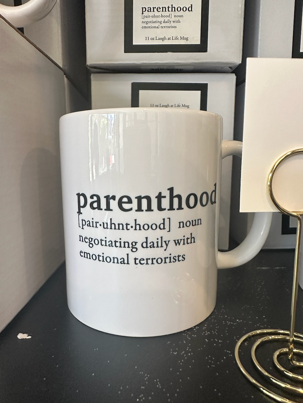 A white mug with the word parenthood on it