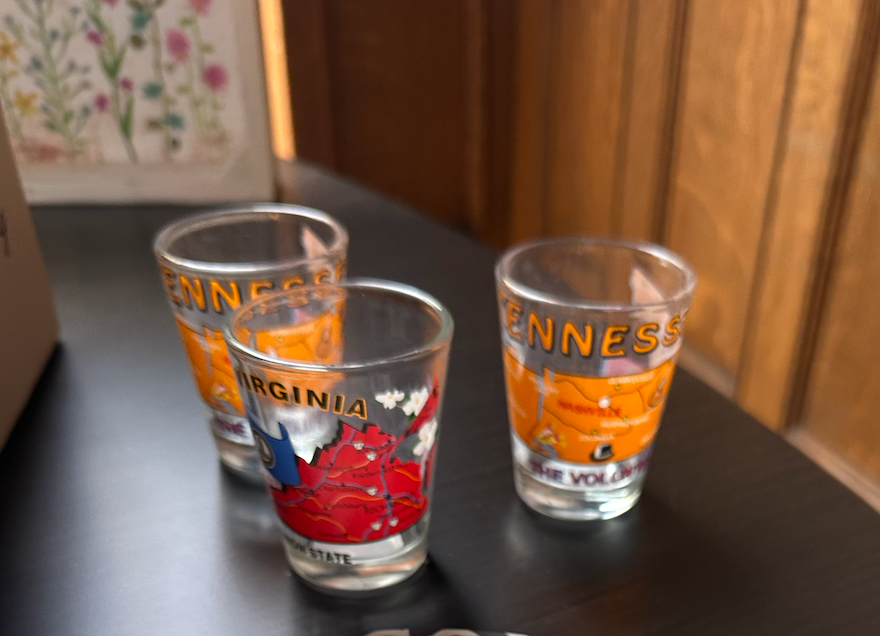 Three shot glasses with virginia on them are sitting on a table.