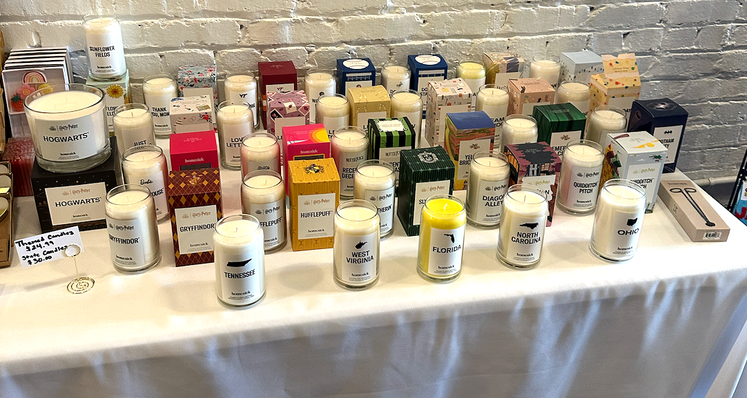 Learn More About Treasure A table with dozens of unique candles at Treasure - The Gift Store