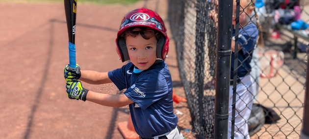 Baseball player sliding into home plate, catcher in front. Blue and gold uniforms, action shot.