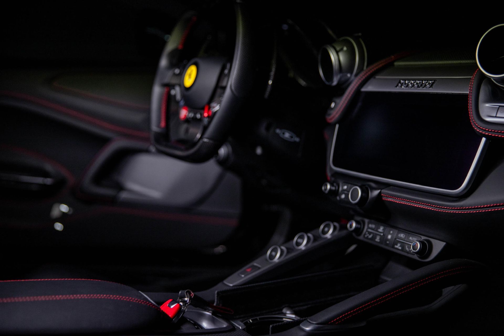 The interior of a ferrari car with a steering wheel and a dashboard.