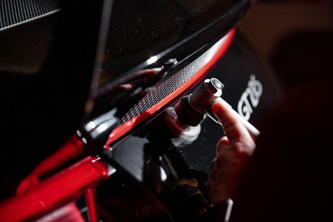 A close up of a person holding a screw on a motorcycle