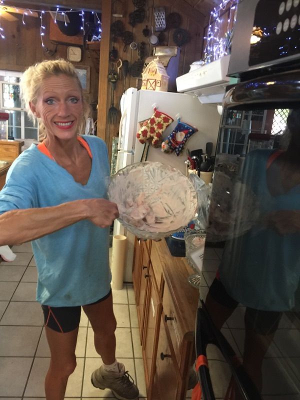 A woman in a blue shirt is holding a bowl of food