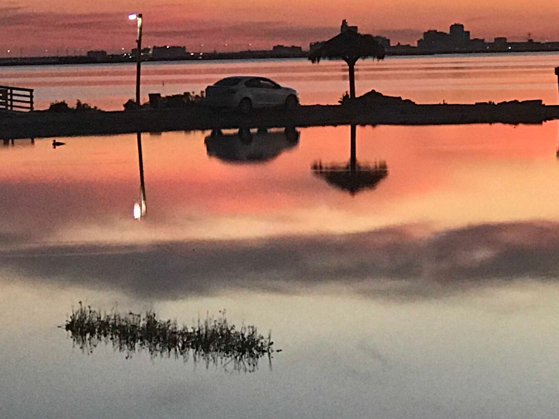 A car is parked in the water at sunset