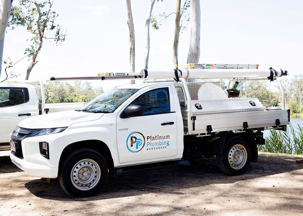 Utility trucks and trailers parked in a lot under a blue sky, one towing another with a blue sign on the side Utility trucks and trailers parked in a lot under a blue sky, one towing another with a blue sign on the side