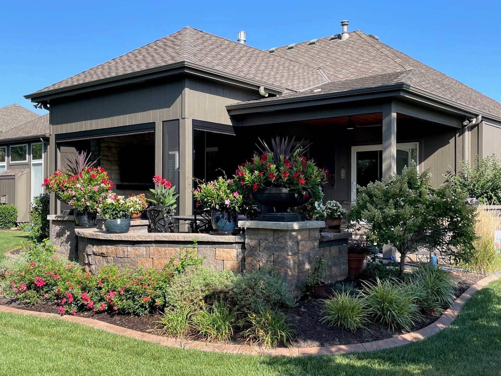 A house with a porch and flowers in front of it.