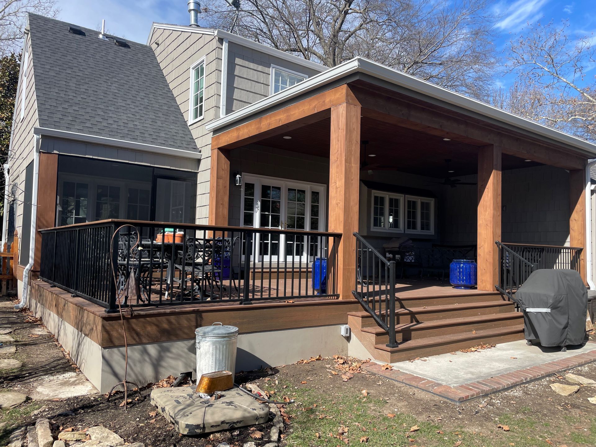 A house with a screened in porch and a large deck.