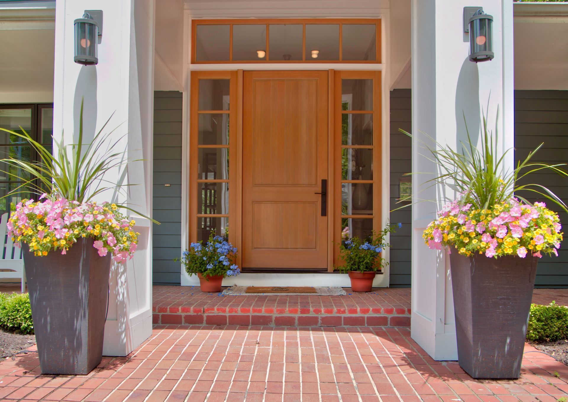 A house with a wooden door and potted plants in front of it
