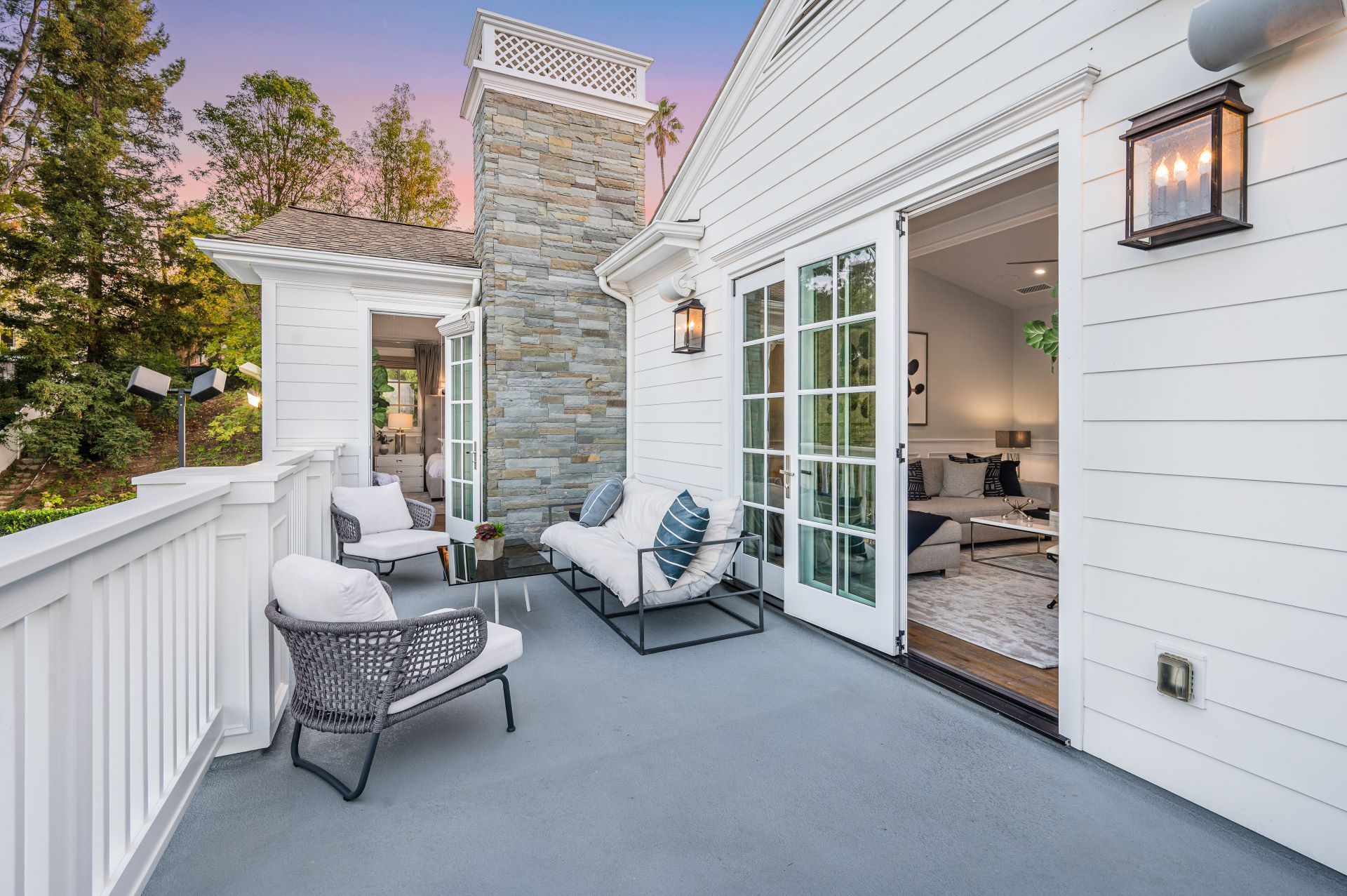 A brown house with a stone fireplace on the front porch