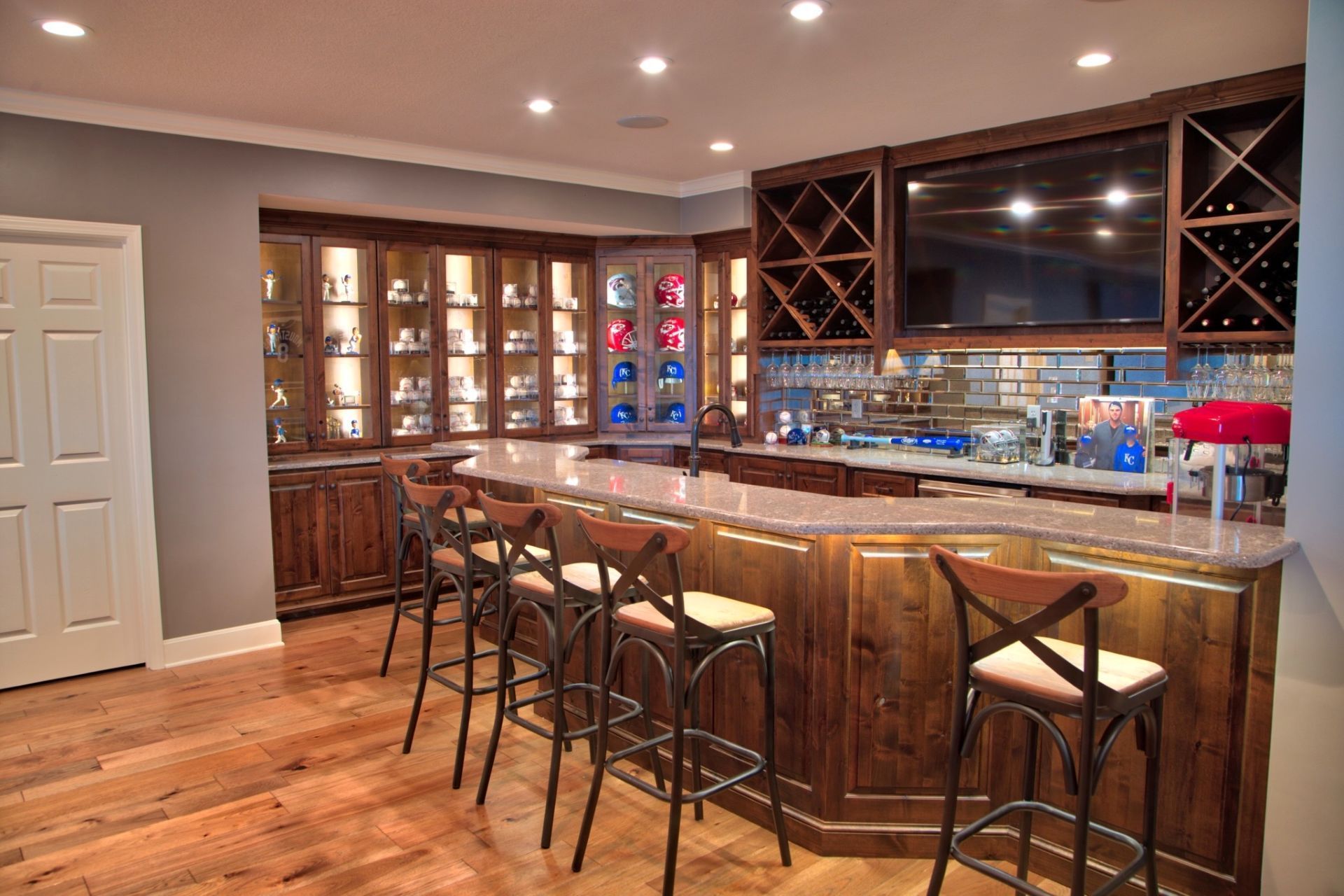 A bar with stools and a wine rack in a basement.