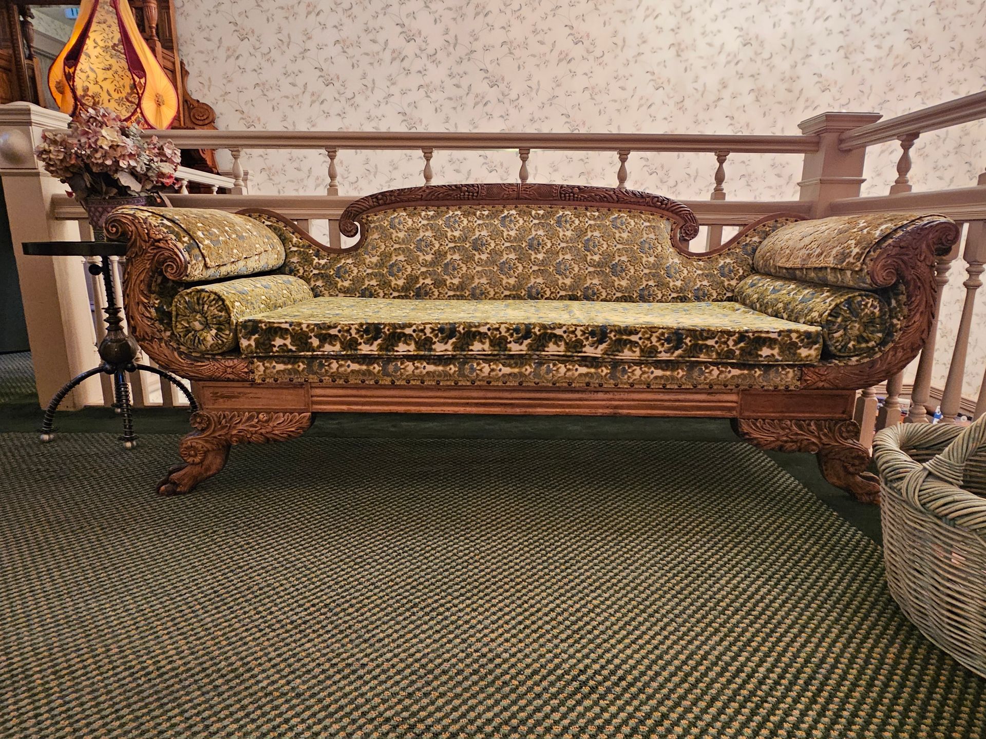 A couch is sitting in a room next to a staircase.