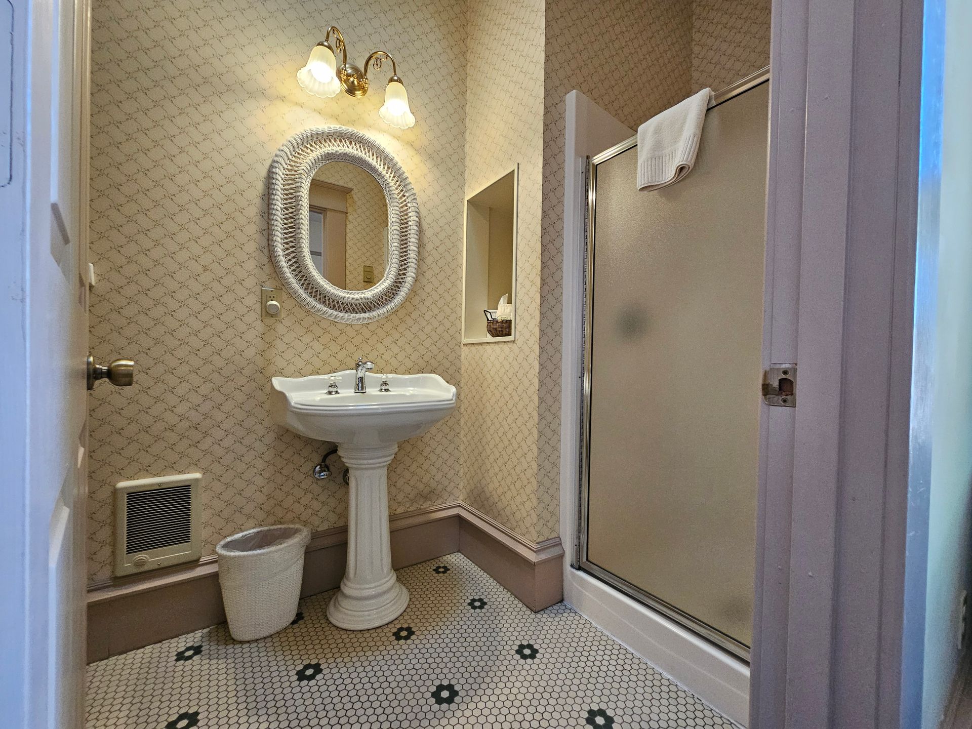 A bathroom with a sink , mirror and shower.