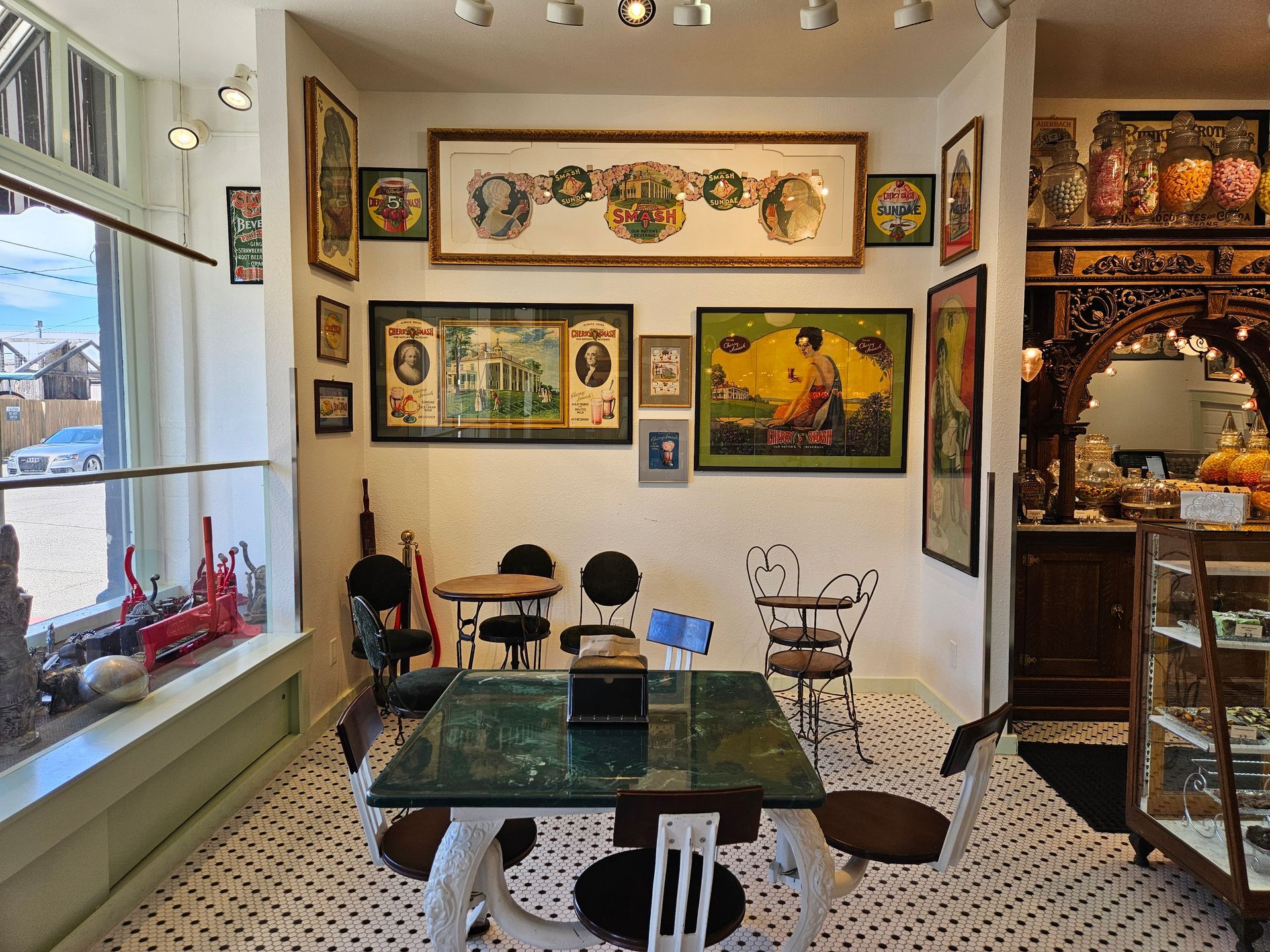 A room with a table and chairs and paintings on the wall