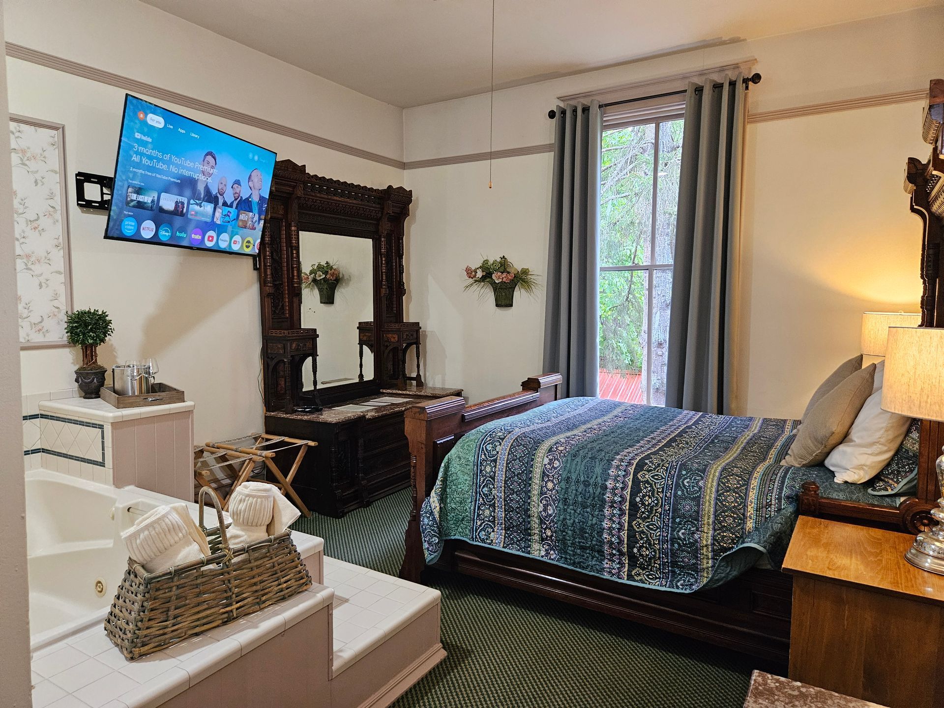 A hotel room with a king size bed and a jacuzzi tub.