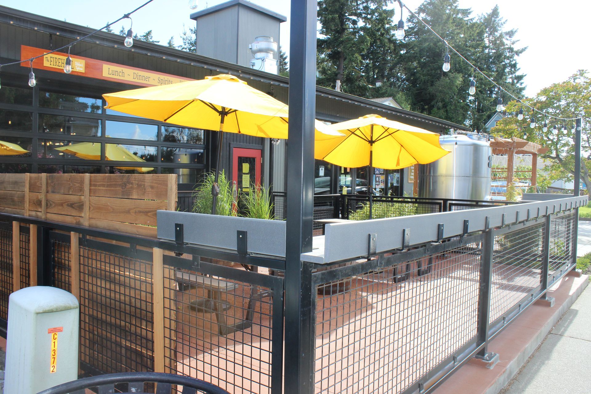 A restaurant with yellow umbrellas behind a fence