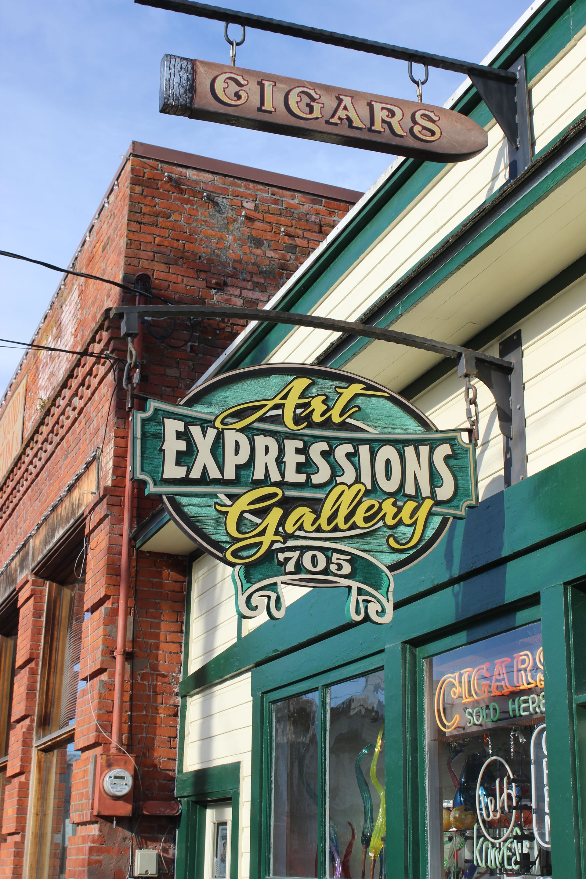 A sign hanging from the side of a building that says art expressions gallery