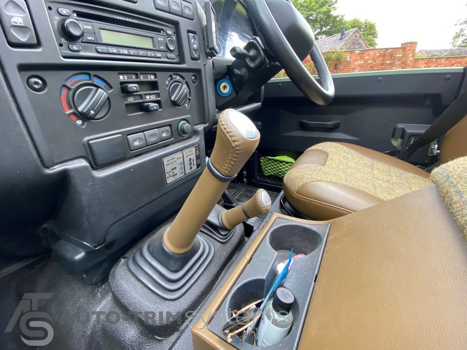 Light green Landrover Defender with customised leather gear sticks