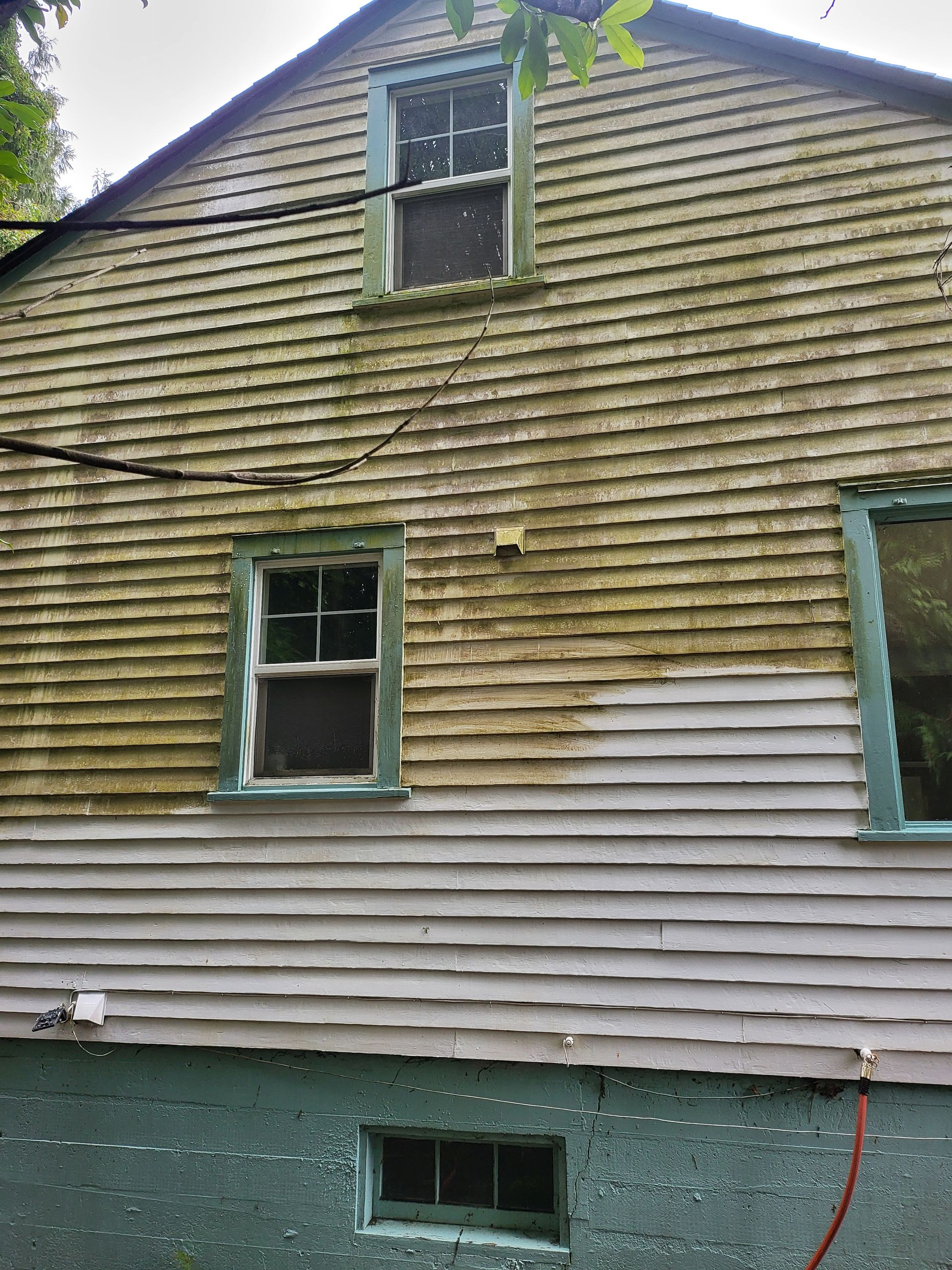 Before: A house exterior covered in dirt and grime, with algae and discoloration visible on the siding and windows