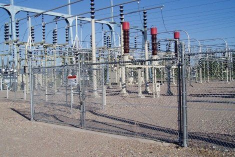 A fence surrounds a large electrical substation