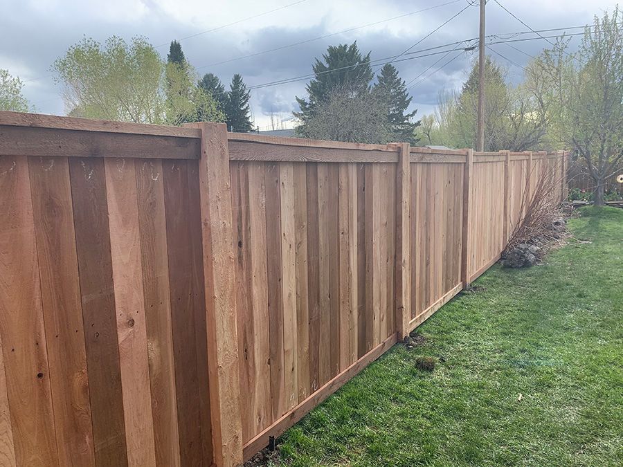 A wooden fence is sitting in the middle of a lush green field.