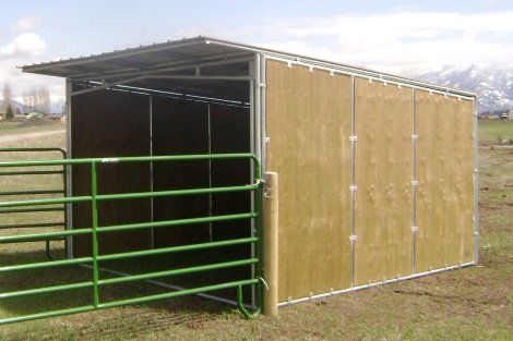 A shed with a fence around it is in a field.