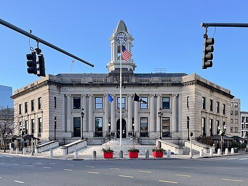Old Town Hall in Stamford, CT. It is a 2-story brick building with a spire in the middle.