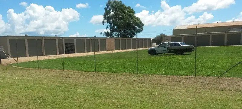 A Grassy Yard With a Security Fence — Tableland Self Storage In Atherton, QLD