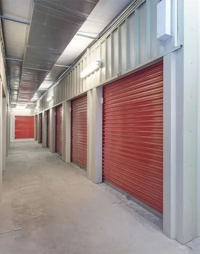 Storage Units, Red Roll-up Doors Line a Hallway — Tableland Self Storage In Atherton, QLD