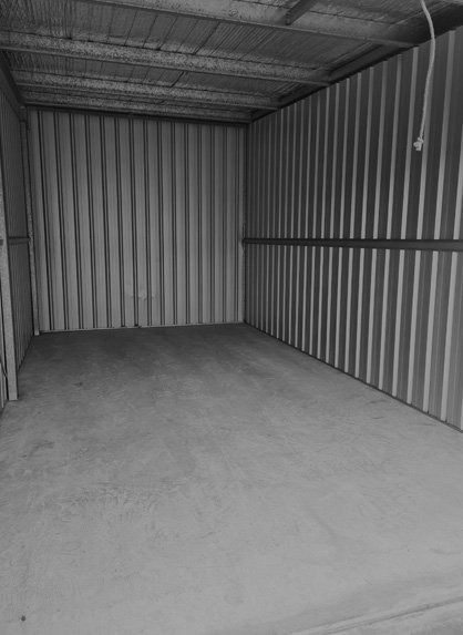 Empty Storage Unit With Corrugated Metal Walls and Concrete Floor — Tableland Self Storage In Atherton, QLD