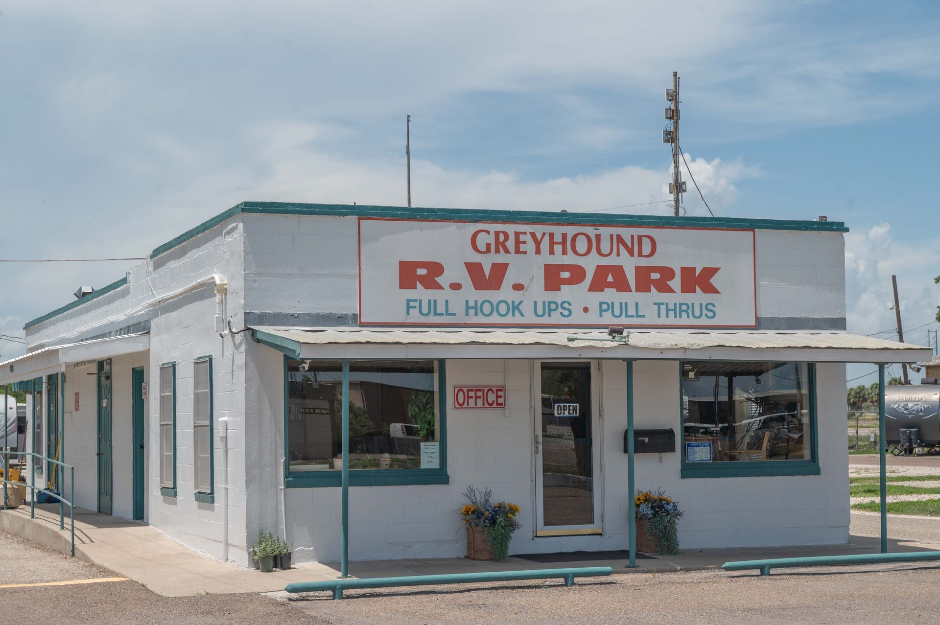 Small white building labeled “Greyhound R.W. Park” with a covered porch in a rural setting