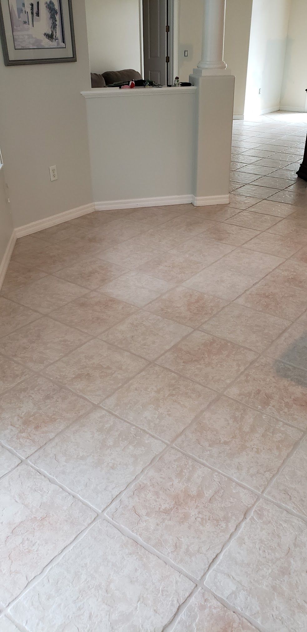 A living room with a tiled floor and a white wall.