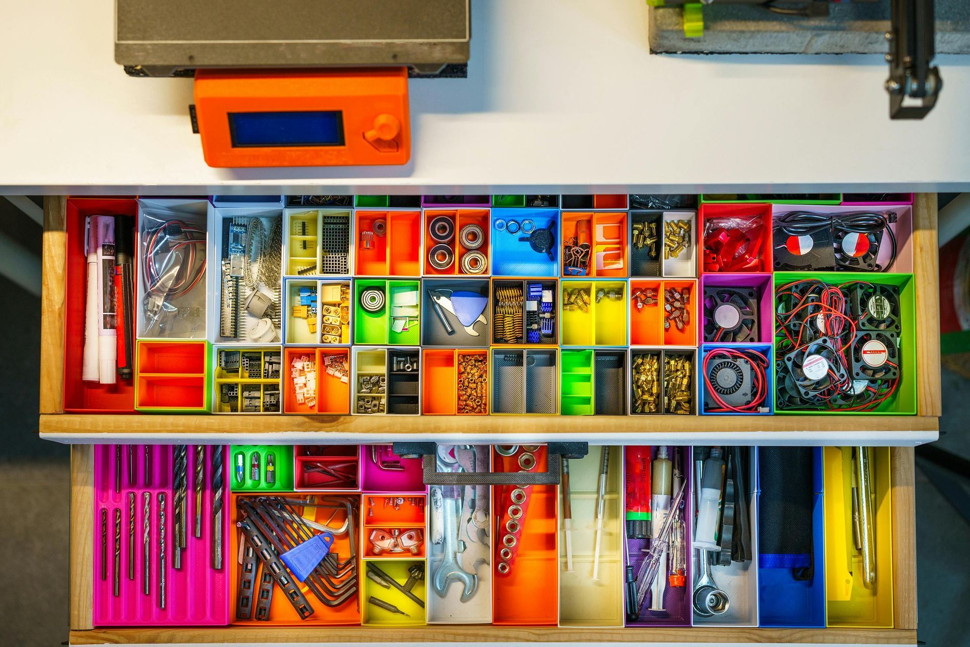 Neatly organized drawer of colorful art supplies and craft tools in compartments